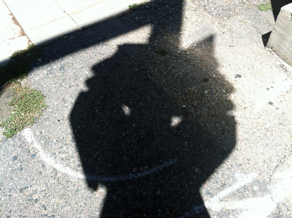 a "face" on the sidewalk made from shadow and chalk